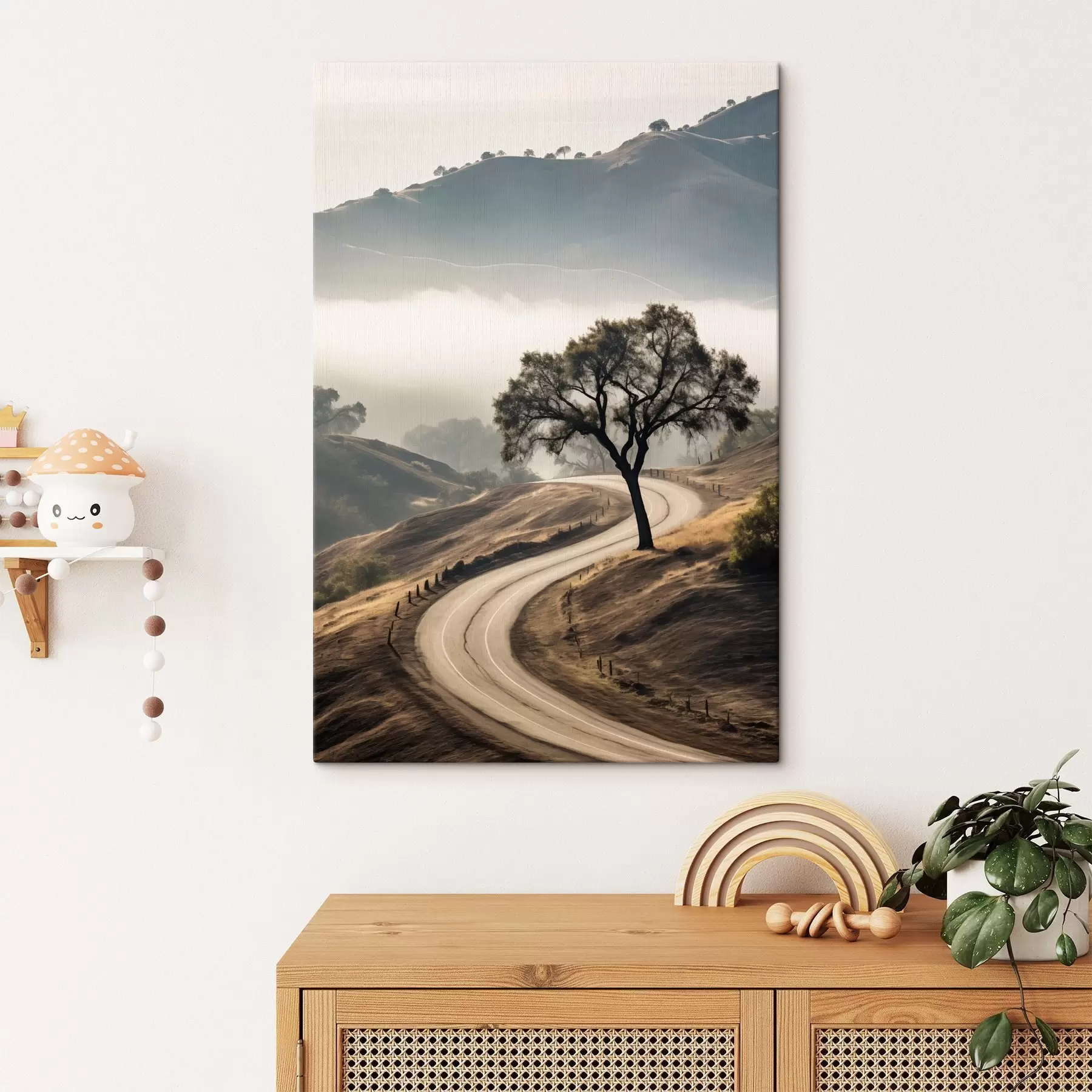 Wandbilder Eine kurvenreiche Straße durch sanfte Hügel mit einem Baum im Vordergrund, im Hintergrund Nebel und Berge s46288