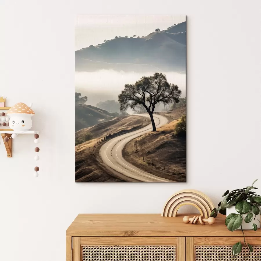Wandbilder Eine kurvenreiche Straße durch sanfte Hügel mit einem Baum im Vordergrund, im Hintergrund Nebel und Berge s46288
